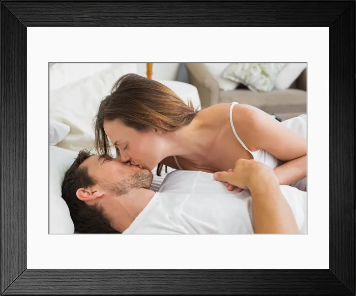 Framed Print : Relaxed couple kissing in bed Framed Print : Relaxed couple kissing in bed