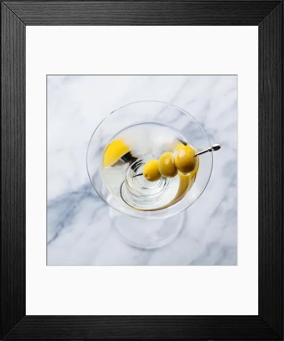 Framed Print : Martini cocktail with green olives on marble board. Copy space. Top view Framed Print : Martini cocktail with green olives on marble board. Copy space. Top view