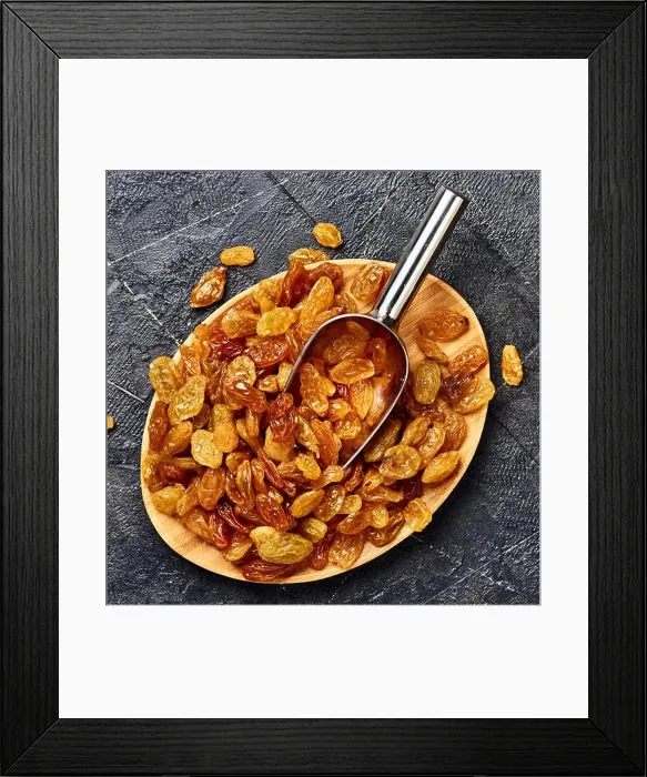 Framed Print : Yellow big raisins on black concrete background. Top view of dried grapes Framed Print : Yellow big raisins on black concrete background. Top view of dried grapes
