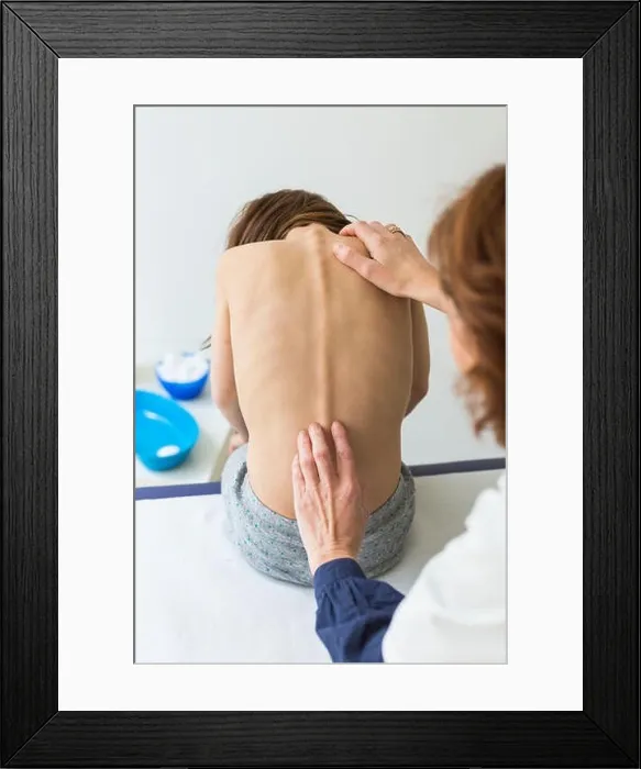 Framed Print : Doctor examining back of 7 year old girl