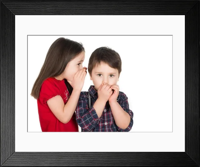 Framed Print : Girl whispering in a little boy`s ear. Boy covering his mouth with his hands. Scared or he cant believe. Isolated on a white background Framed Print : Girl whispering in a little boy`s ear. Boy covering his mouth with his hands. Scared or he cant believe. Isolated on a white background