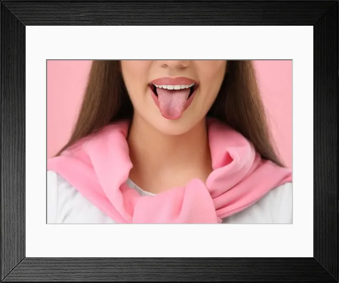 Framed Print : Woman showing her tongue on pink background, closeup Framed Print : Woman showing her tongue on pink background, closeup