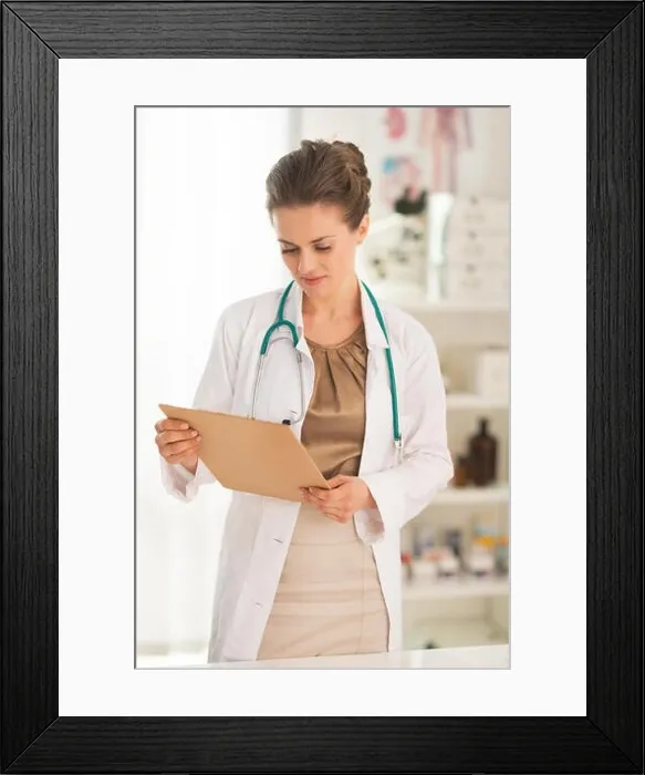 Framed Print : Doctor woman looking in clipboard Framed Print : Doctor woman looking in clipboard