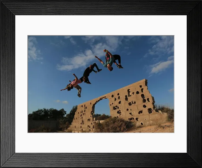 Framed Print : Palestinian youth are seen jumping in the same style during their Parkour practice at the war-torn stones Framed Print : Palestinian youth are seen jumping in the same style during their Parkour practice at the war-torn stones