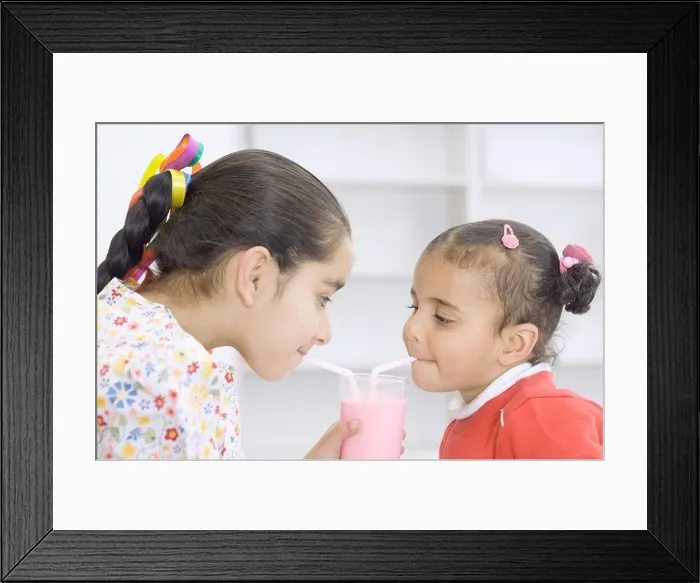 Framed Print : Two girls drinking a glass of milk shake