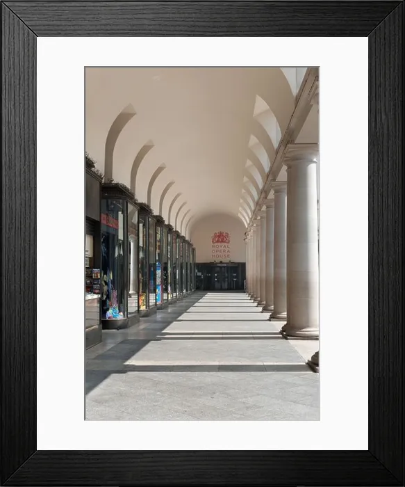 Framed Print : sunlit walkway under and trough shop lined fronts and columns to entrance Royal Opera House