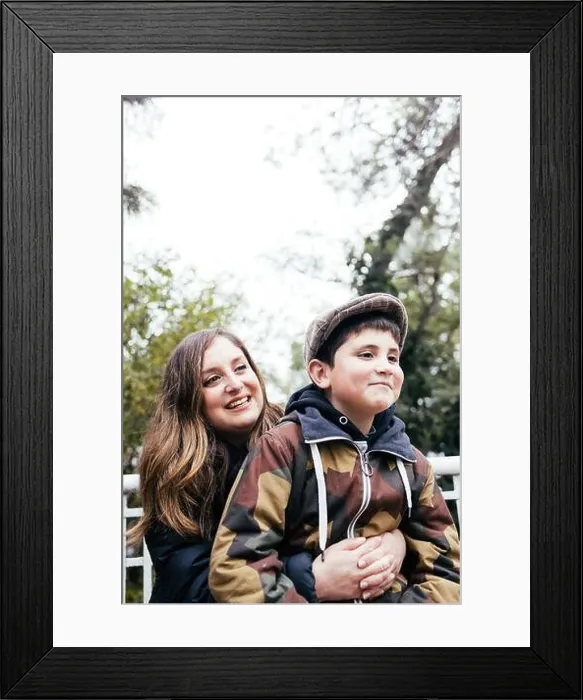 Framed Print : Single mother hugging her young son in the park. Single parent family Framed Print : Single mother hugging her young son in the park. Single parent family