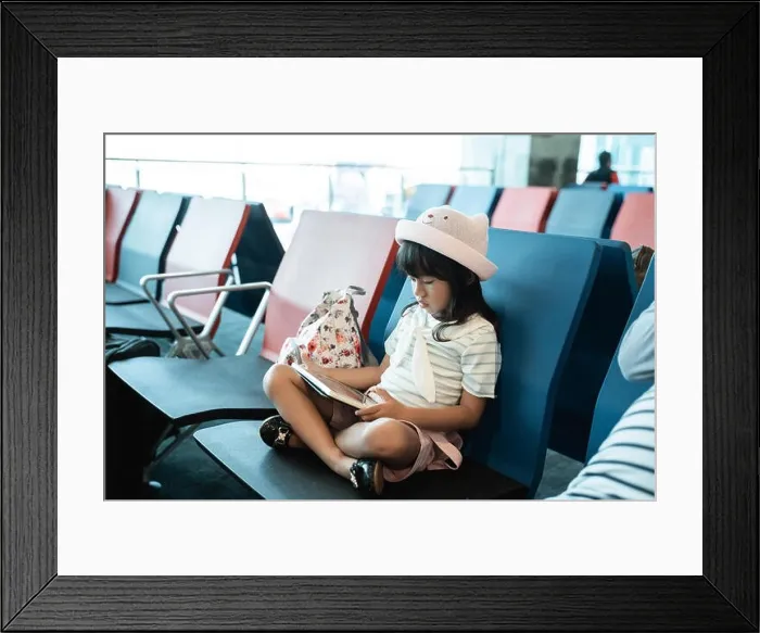 Framed Print : little girl enjoy play the game when sitting and hold a tab Framed Print : little girl enjoy play the game when sitting and hold a tab