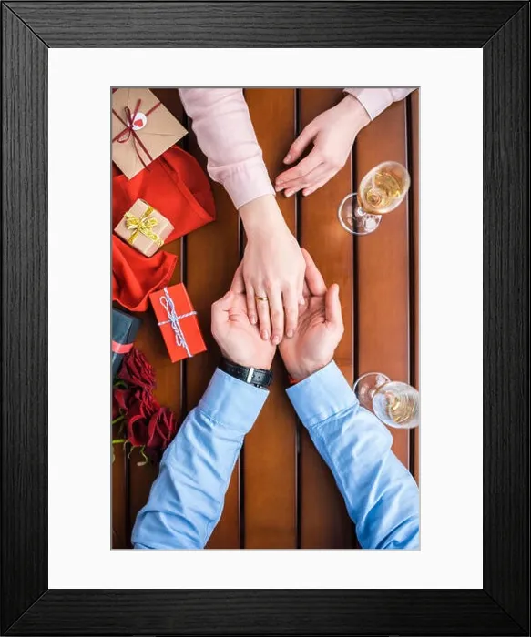 Framed Print : cropped image of boyfriend holding girlfriends hand with wedding ring Framed Print : cropped image of boyfriend holding girlfriends hand with wedding ring