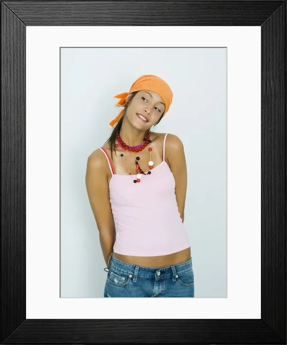 Framed Print : Teenage girl standing with arms behind back and head tilted, looking away Framed Print : Teenage girl standing with arms behind back and head tilted, looking away