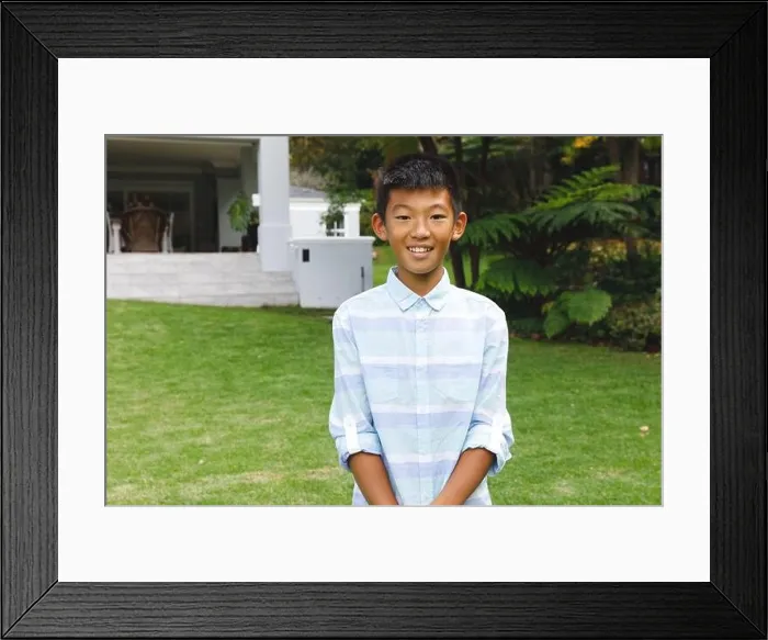 Framed Print : Portrait of smiling asian boy smiling outdoors and wearing casual clothes in garden