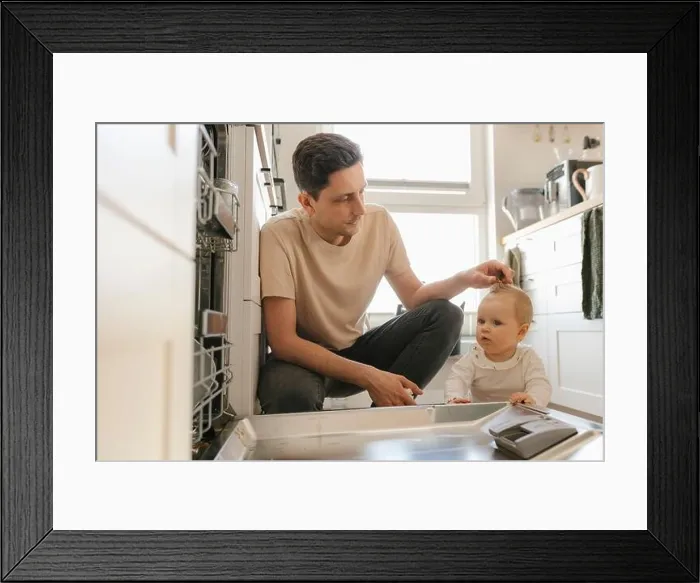 Framed Print : Cute baby girl and father loading utensils in dishwasher in kitchen at home Framed Print : Cute baby girl and father loading utensils in dishwasher in kitchen at home
