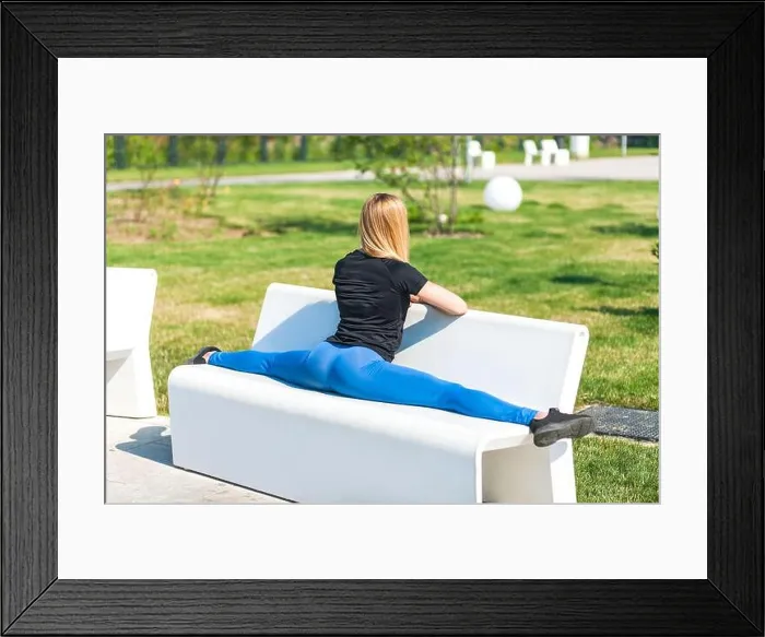 Framed Print : young woman doing split on concrete bench in the park