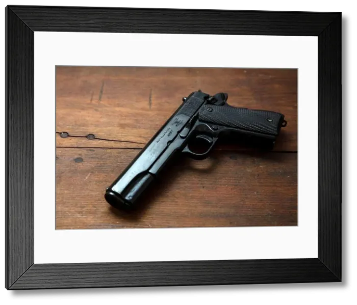Framed Print : 9mm Pistol gun on wooden background. Black metal weapon, automatic handgun for military and security on a vintage table. Side view Framed Print : 9mm Pistol gun on wooden background. Black metal weapon, automatic handgun for military and security on a vintage table. Side view
