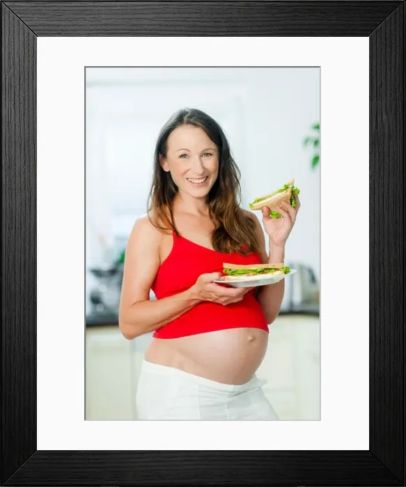 Framed Print : Pregnant woman holding sandwiches