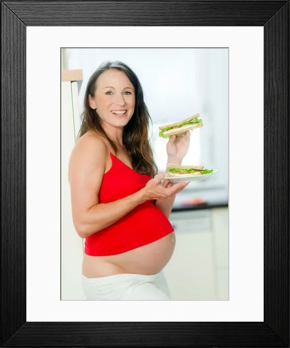 Framed Print : Schwangere Frau isst ein Sandwich - pregnant woman eats a sandwich Framed Print : Schwangere Frau isst ein Sandwich - pregnant woman eats a sandwich