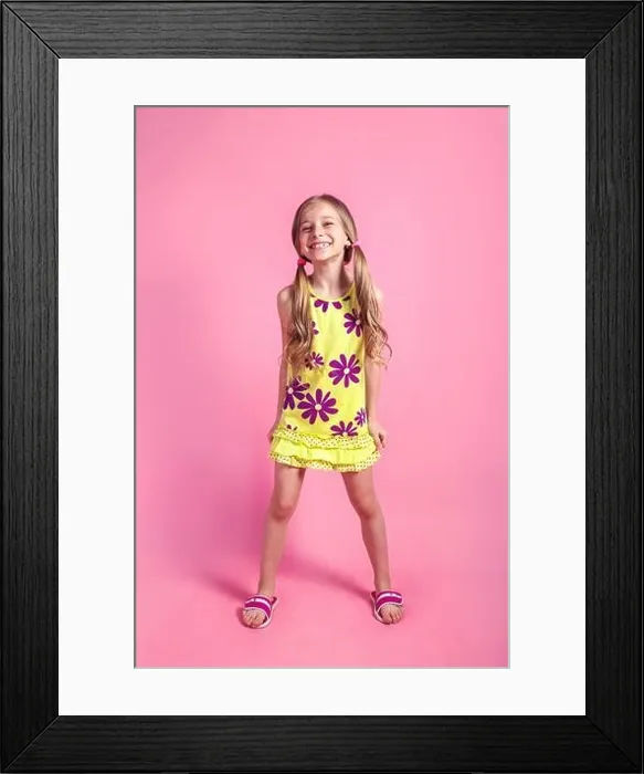 Framed Print : Cheerful little child girl in summer dress posing on a colored pink background Framed Print : Cheerful little child girl in summer dress posing on a colored pink background