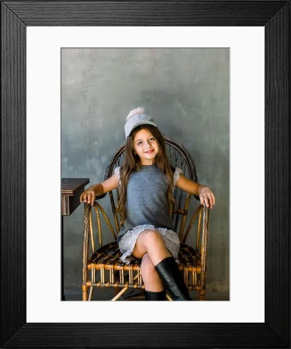 Framed Print : Beautiful little girl with brown long hair and blue eyes sitting in an armchair dressed in gray dress and a hat Framed Print : Beautiful little girl with brown long hair and blue eyes sitting in an armchair dressed in gray dress and a hat