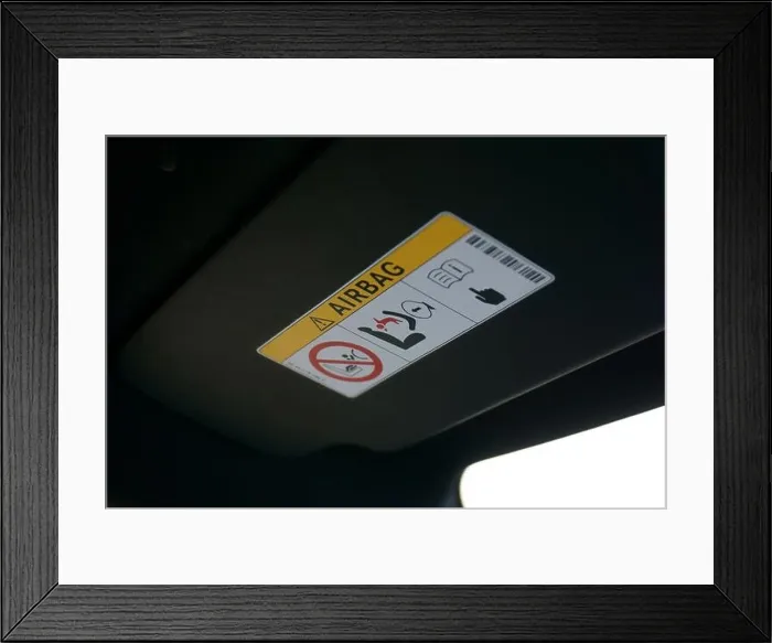 Framed Print : Airbag warning label on sun visor of a car Framed Print : Airbag warning label on sun visor of a car