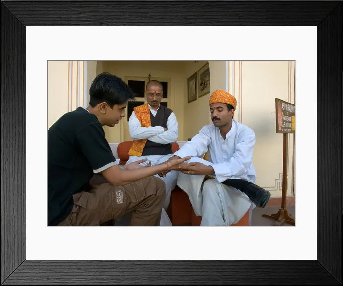 Framed Print : Traditional Indian astrologers (or palmists) reading into a young lad's future Framed Print : Traditional Indian astrologers (or palmists) reading into a young lad's future