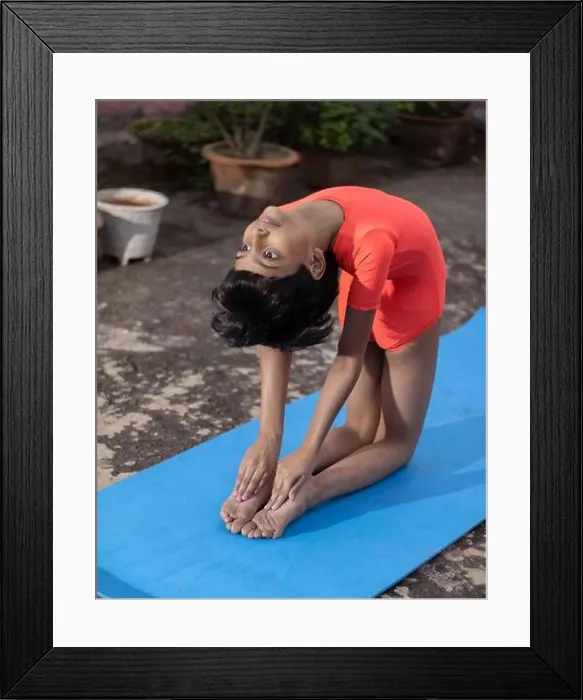 Framed Print : An Indian girl child practicing Ustrasana yoga on yoga mat outdoors Framed Print : An Indian girl child practicing Ustrasana yoga on yoga mat outdoors