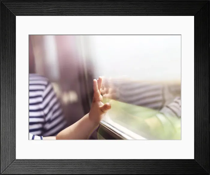 Framed Print : Boy travelling in retro train. He is touching the window Framed Print : Boy travelling in retro train. He is touching the window