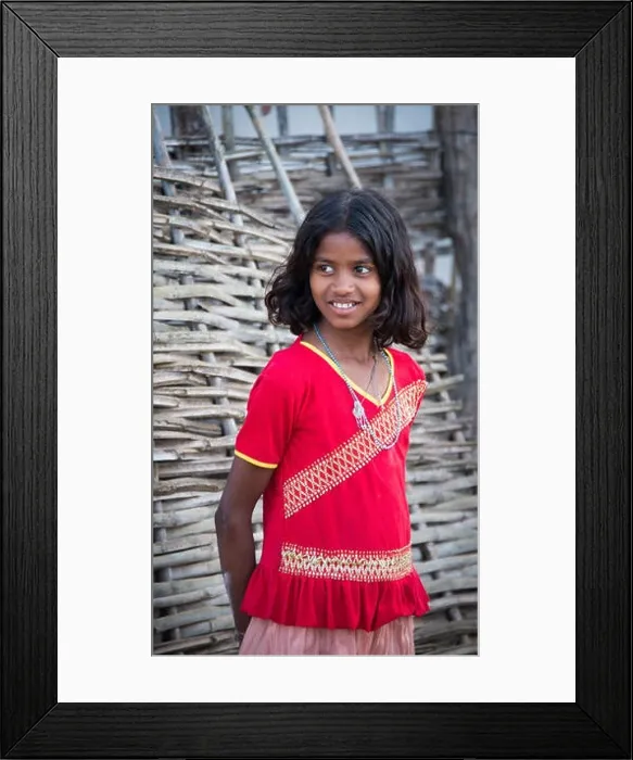Framed Print : A local indian girl stands outside her house to see tourists walking by in Kanha village near the Kanha National Park, in India Framed Print : A local indian girl stands outside her house to see tourists walking by in Kanha village near the Kanha National Park, in India