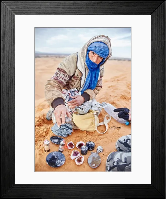 Framed Print : Berber man in the Sahara desert offers its own Souvenirs, and precious stones. Bedouin sitting on the sand on the dune. Morocco, Merzouga, 16 December Framed Print : Berber man in the Sahara desert offers its own Souvenirs, and precious stones. Bedouin sitting on the sand on the dune. Morocco, Merzouga, 16 December