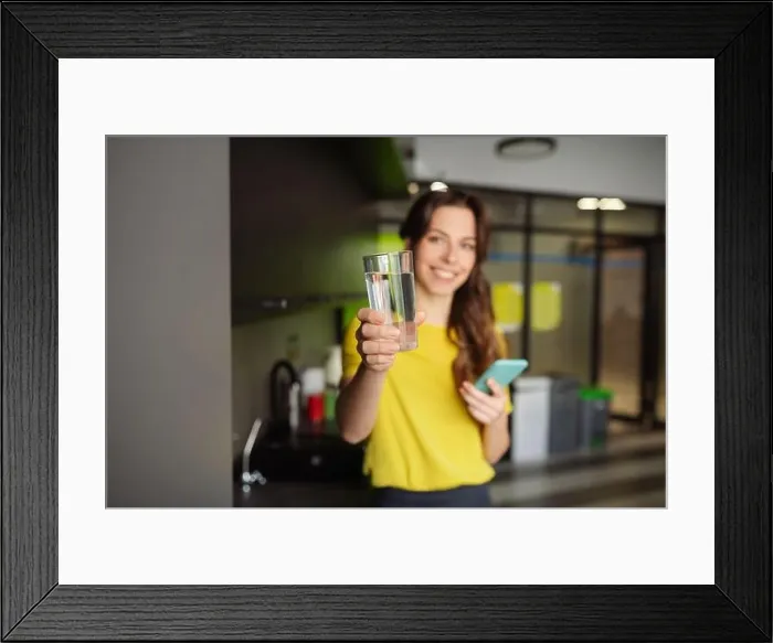 Framed Print : Beautiful slender girl holding a glass of water forward