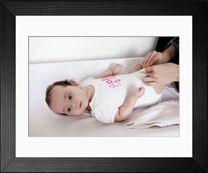 Framed Print : baby girl on the changing table, diaper change Framed Print : baby girl on the changing table, diaper change