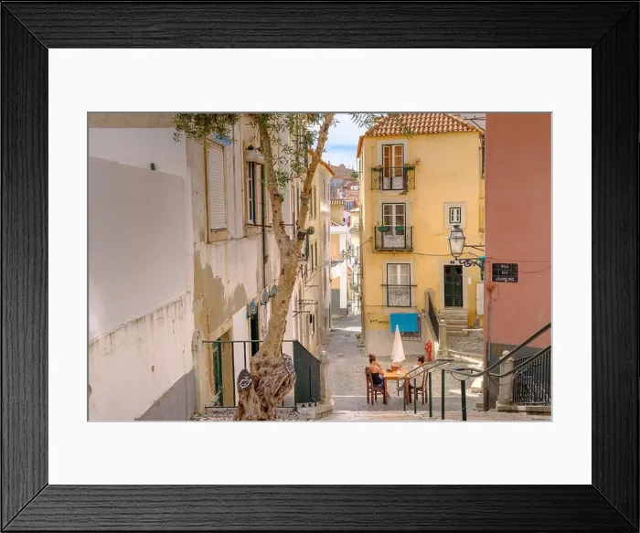 Framed Print : Backstreets of Alfama Neighborhood with woman relaxing, Lisbon, Portugal Framed Print : Backstreets of Alfama Neighborhood with woman relaxing, Lisbon, Portugal
