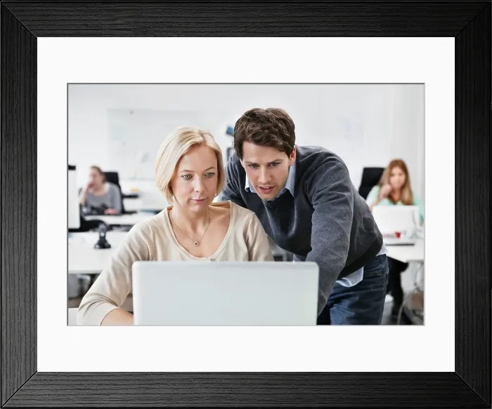 Framed Print : Man helping colleague with computer Framed Print : Man helping colleague with computer