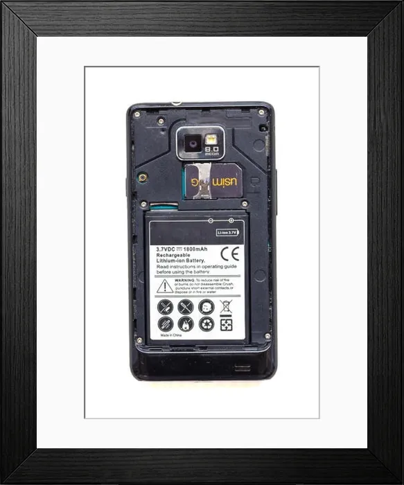 Framed Print : Back view of old smartphone with open cover isolated on white background. The battery and sim card are visible Framed Print : Back view of old smartphone with open cover isolated on white background. The battery and sim card are visible