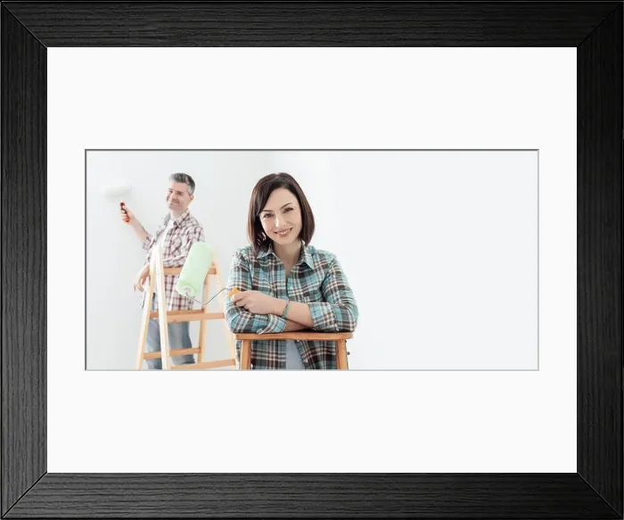 Framed Print : Couple painting their house, the woman is smiling on the foreground and the man is working on the background Framed Print : Couple painting their house, the woman is smiling on the foreground and the man is working on the background