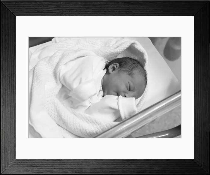 Framed Print : Newborn baby girl a few hours old asleep in hospital cot Framed Print : Newborn baby girl a few hours old asleep in hospital cot