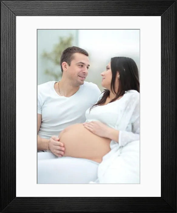 Framed Print : Pregnant woman with her husband relaxing at home Framed Print : Pregnant woman with her husband relaxing at home