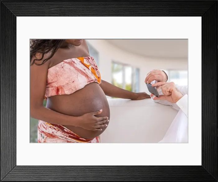 Framed Print : Handsome man takes photos with smartphone of young happy pregnant woman living room