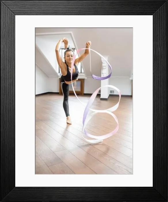 Framed Print : Athletic woman practising rhythmic gymnastics with a ribbon in the gym Framed Print : Athletic woman practising rhythmic gymnastics with a ribbon in the gym