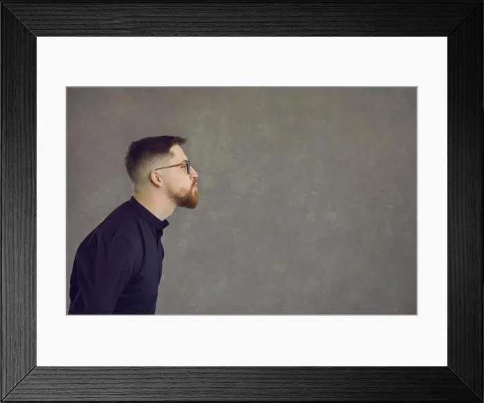 Framed Print : Side view of funny man pouting lips and kissing empty space on copy space background Framed Print : Side view of funny man pouting lips and kissing empty space on copy space background