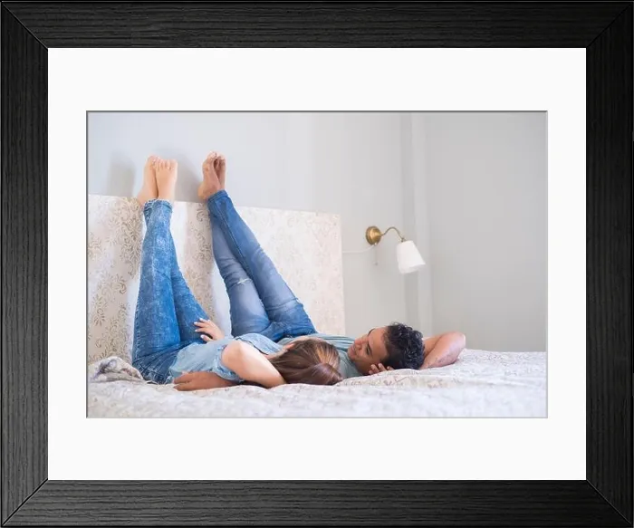Framed Print : Young couple boy and girl lay down on bed in the bedroom at home or hotel - love and relationship happy couple together in the morning - real lifestyl Framed Print : Young couple boy and girl lay down on bed in the bedroom at home or hotel - love and relationship happy couple together in the morning - real lifestyl