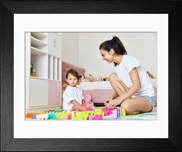 Framed Print : cute caucasian baby girl and her mother playing with toy bricks in the children room, having fun together Framed Print : cute caucasian baby girl and her mother playing with toy bricks in the children room, having fun together