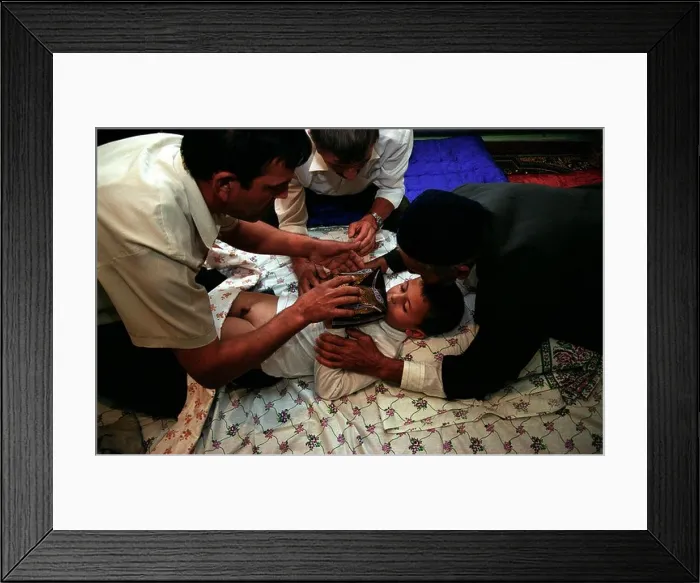 Framed Print : The circumcision master and the closest male relatives of the boy gather near the bed for a prayer Framed Print : The circumcision master and the closest male relatives of the boy gather near the bed for a prayer