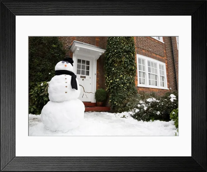 Framed Print : Snowman at the front door of a house in winter Framed Print : Snowman at the front door of a house in winter