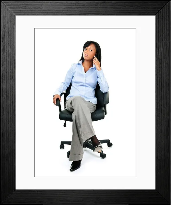 Framed Print : Young confident black businesswoman on phone sitting in leather office chair Framed Print : Young confident black businesswoman on phone sitting in leather office chair