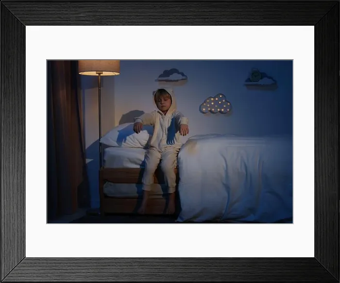 Framed Print : Boy in pajamas sleepwalking indoors at night