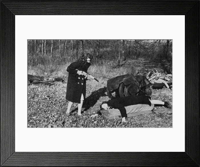 Framed Print : Woman holds fake machine gun on couple on the ground, USA, circa 1940 Framed Print : Woman holds fake machine gun on couple on the ground, USA, circa 1940