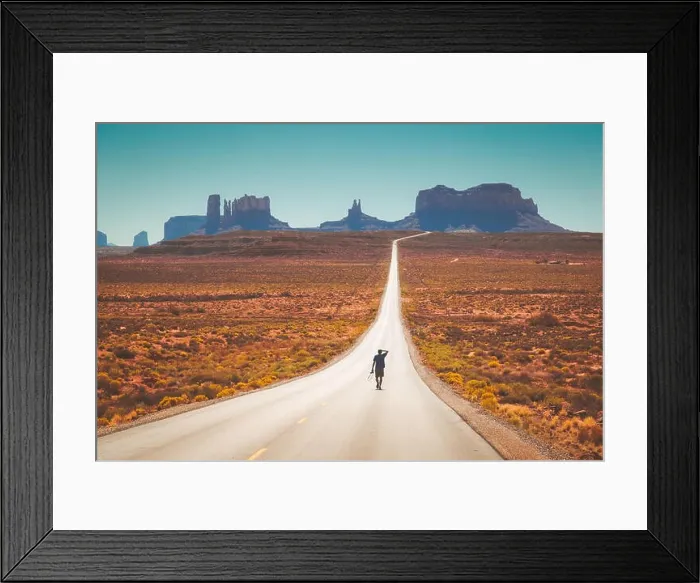 Framed Print : Classic panorama view of young man walking on famous Forrest Gump Road in Monument Valley at noon, Utah, American West, USA Framed Print : Classic panorama view of young man walking on famous Forrest Gump Road in Monument Valley at noon, Utah, American West, USA