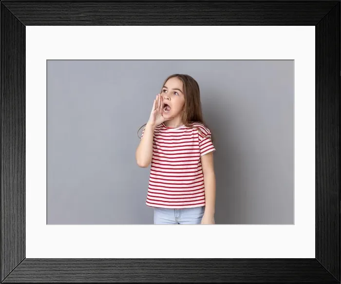 Framed Print : Attention, announcement. Portrait of dark haired adorable little girl wearing striped T-shirt screaming message, loud advertising Framed Print : Attention, announcement. Portrait of dark haired adorable little girl wearing striped T-shirt screaming message, loud advertising