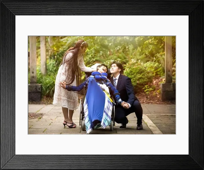 Framed Print : Bride and groom with disabled child in wheelchair outdoors Framed Print : Bride and groom with disabled child in wheelchair outdoors