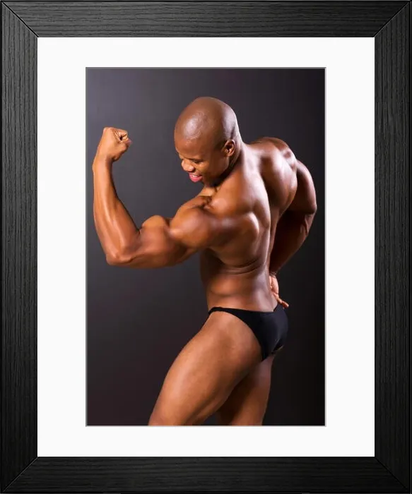 Framed Print : African muscular man showing muscles on black background Framed Print : African muscular man showing muscles on black background